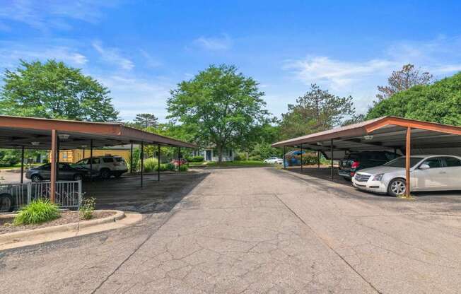 a parking lot with cars parked under roofs