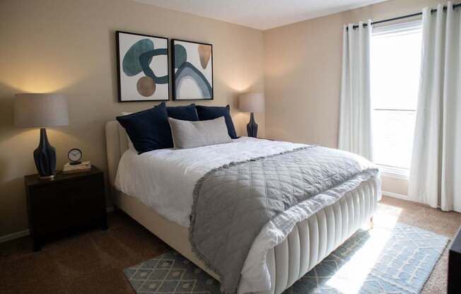 A bedroom with a large bed and a painting on the wall.