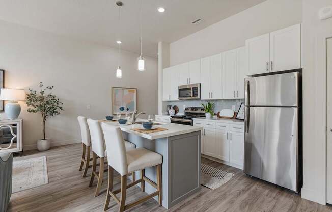 an open kitchen and dining area with a stainless steel refrigerator