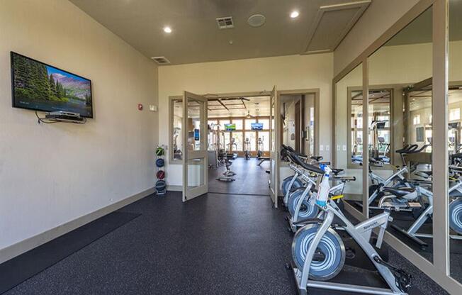 a room with a lot of bikes in it and a tv on the wall