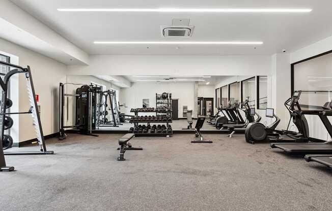 A spacious gym with a variety of equipment including treadmills, weights, and exercise machines.