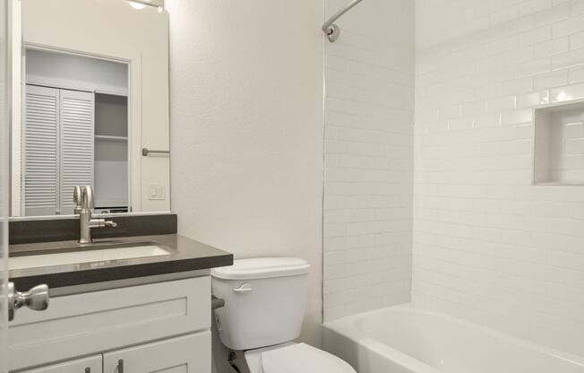 a white bathroom with a toilet and a sink