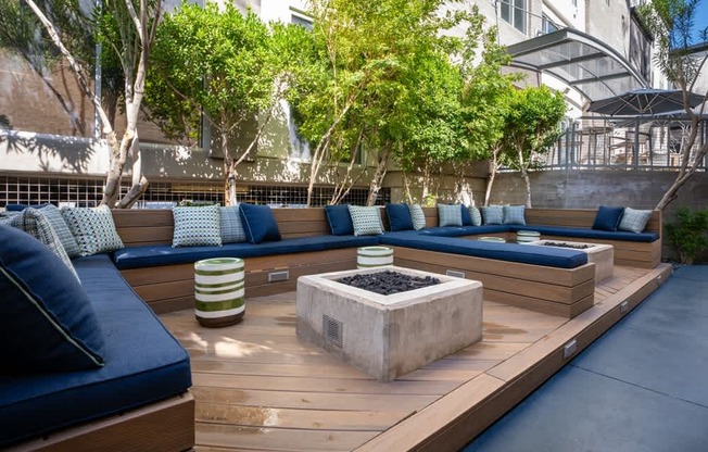 A modern outdoor seating area with blue cushions and wooden benches.
