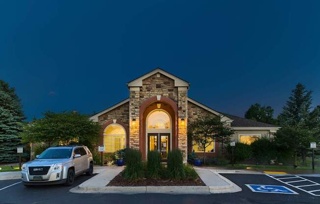 A car is parked in a handicapped parking spot outside a building.