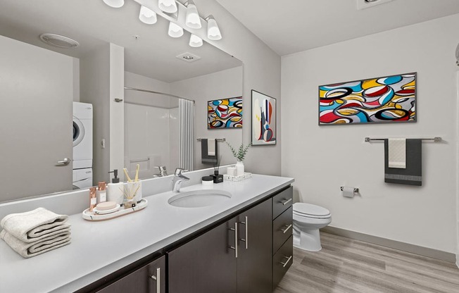 A bathroom with a white counter top and a white toilet.