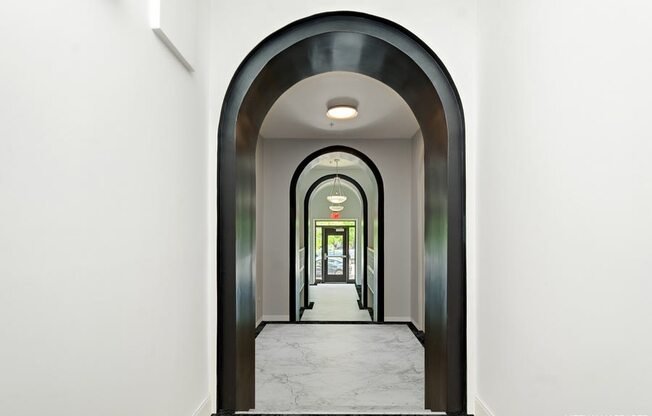 a view down a hallway with a black and white archway and white walls