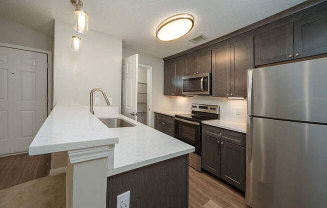 A kitchen with a white countertop and stainless steel appliances.