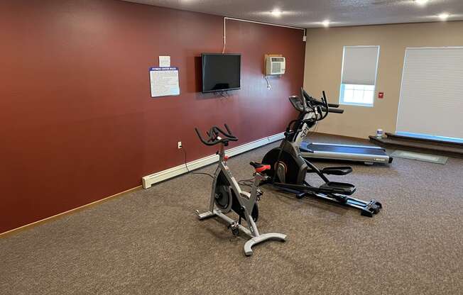 a room with two exercise bikes and a flat screen tv at Bluemont Village Apartments, Fargo, North Dakota