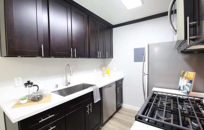 a kitchen with black cabinets and stainless steel appliances and a stove