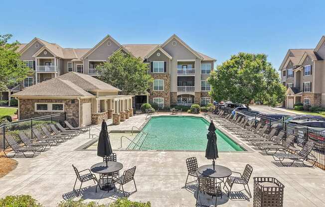 pool with lounge chairs and tables with umbrellas