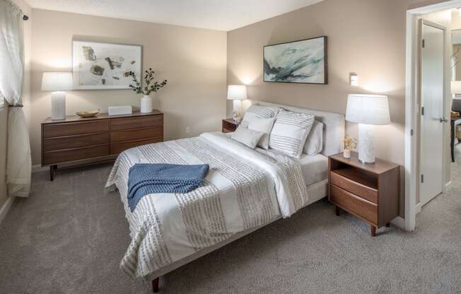 a bedroom with a bed and two nightstands and a closet