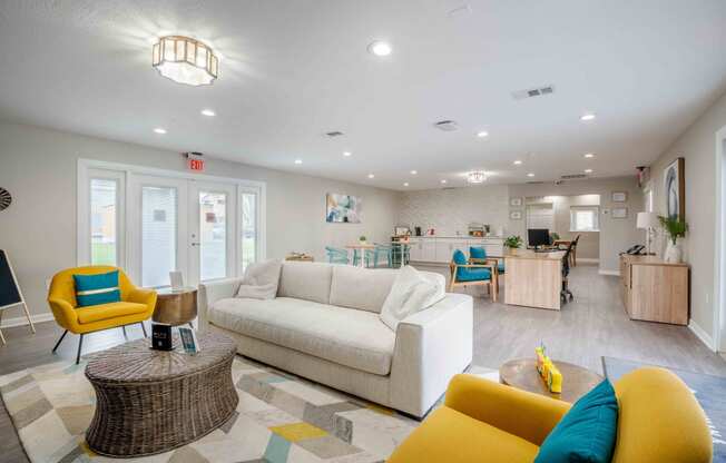 a living room with couches and chairs and a kitchen