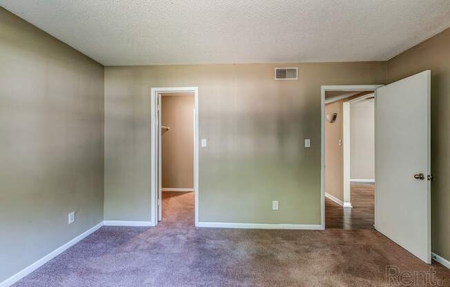 an empty living room with white walls and a carpeted floor