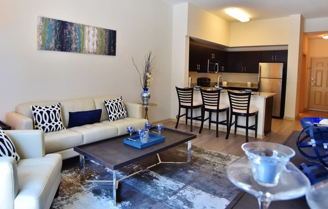 a living room with a couch and a table and a kitchen