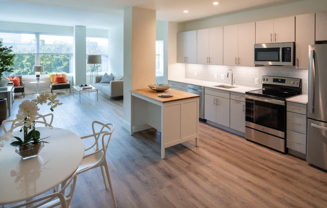 a kitchen and dining room with white cabinets and stainless steel appliances at Sinclaire on Seminary, Virginia, 22311