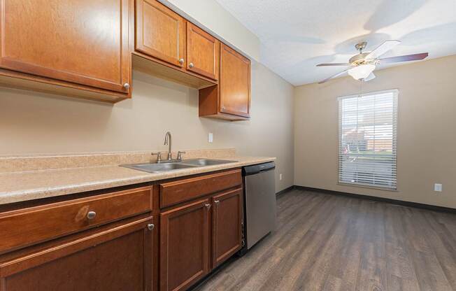 A kitchen with wooden cabinets and a ceiling fan.