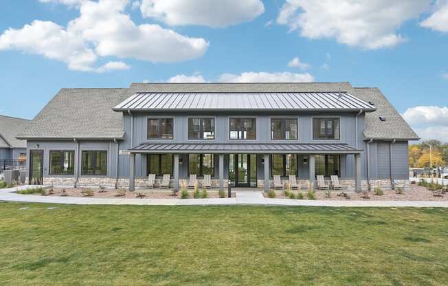 the front of a gray house with windows and a lawn