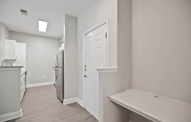 A kitchen with white cabinets and a refrigerator.