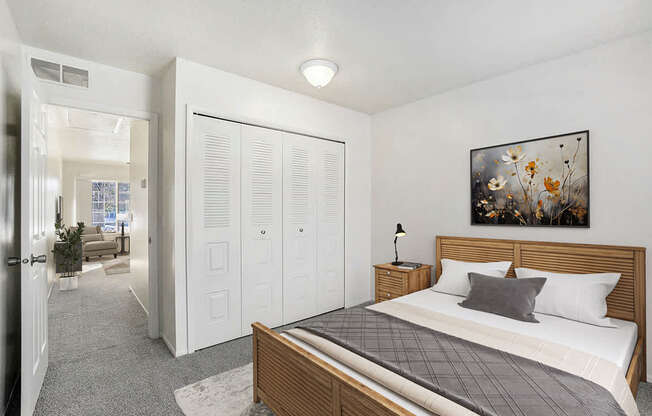 A bedroom with a bed, closet, and plush carpeting at Newport Village Apartments, Portage, MI