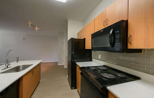 A kitchen with black appliances and wooden cabinets.