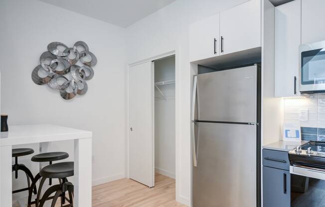 a kitchen with white cabinets and a stainless steel refrigerator