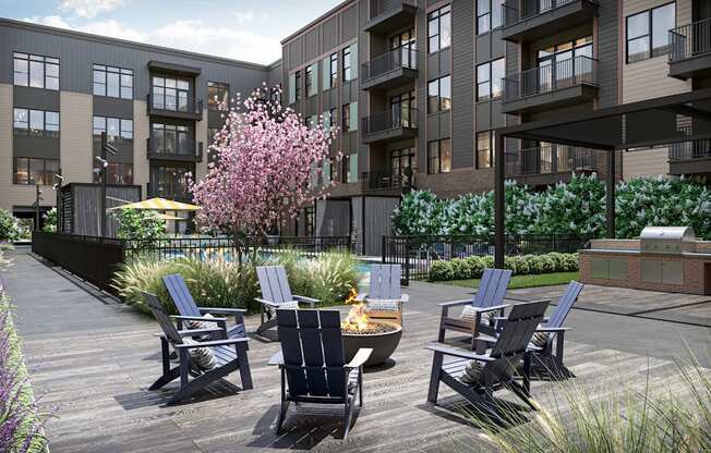 a patio with chairs and a fire pit in front of an apartment building at Link Apartments® Broad Ave, Memphis, Tennessee