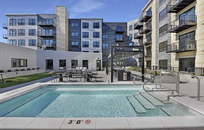 A swimming pool in front of a building with a height restriction sign.