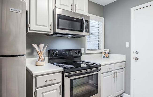 a kitchen with stainless steel appliances and white cabinets