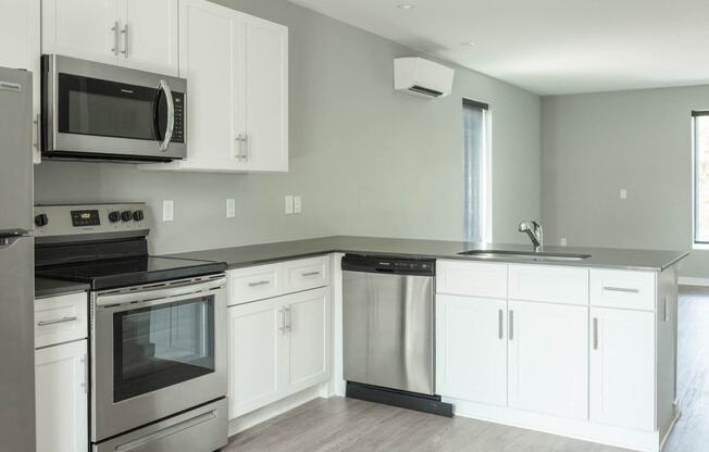 a white kitchen with stainless steel appliances and white cabinets