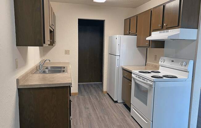 a kitchen with a stove refrigerator and a sink