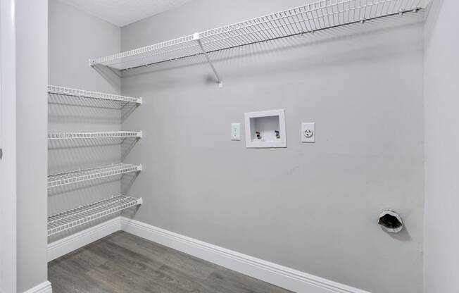 a room with white walls and a white closet with shelves