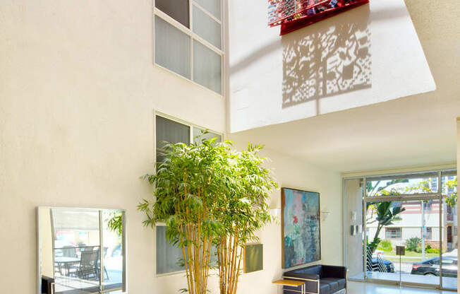 Apartment entry lobby with lush landscaping and artwork