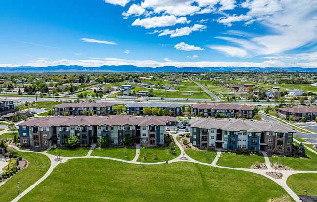 an aerial view of an apartment complex with green grass and a blue sky at Arbour Commons, Colorado, 80023