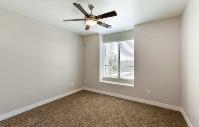 a bedroom with a ceiling fan and a window