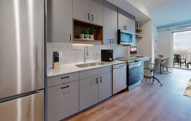 a kitchen with white cabinets and a stainless steel refrigerator