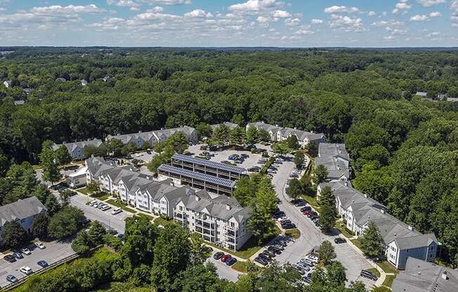 an aerial view of a building surrounded by trees and a parking lot