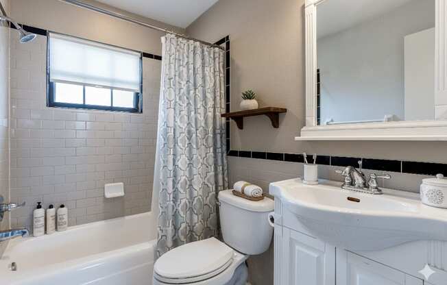 A white toilet sits next to a bathtub in a bathroom.