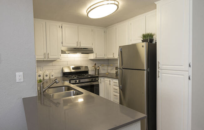 Sacramento, CA Apartments - Vue at the Lake Kitchen with Stainless Steel Appliances and White Cabinetry