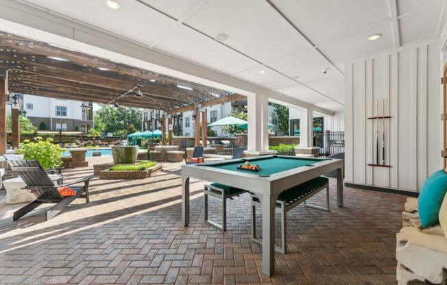 an outdoor patio with a pool table and patio furniture