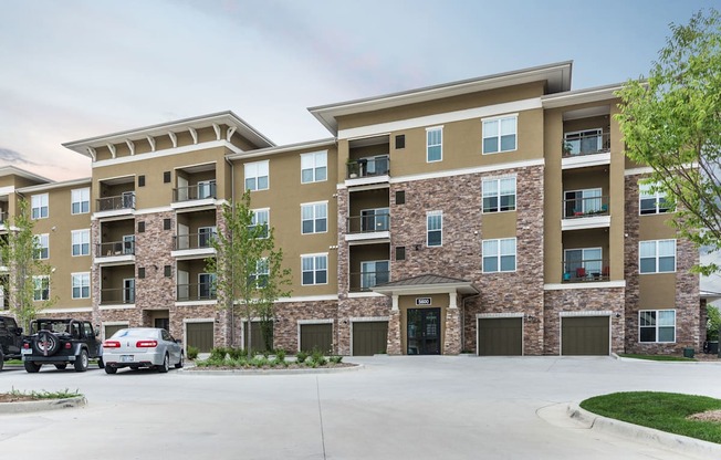 A large apartment complex with a parking lot in front.