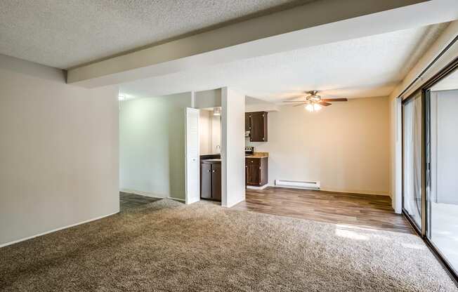 A room with a carpeted floor and a ceiling fan.