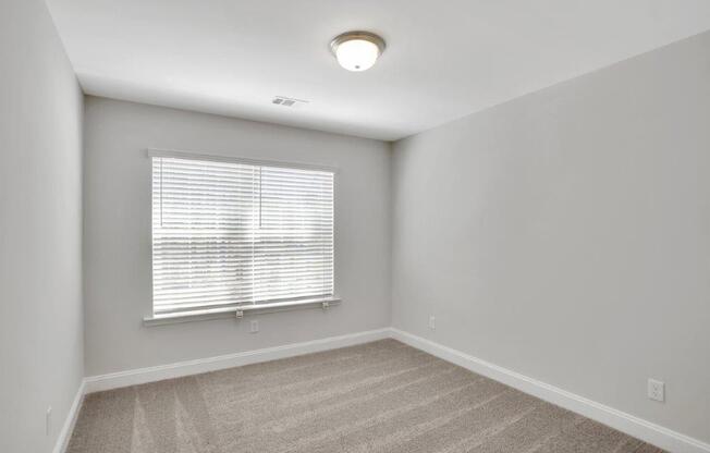 Harris Trail Luxury Townhomes for rent Richmond Hill, GA photo of bedroom with large window and plush carpeting