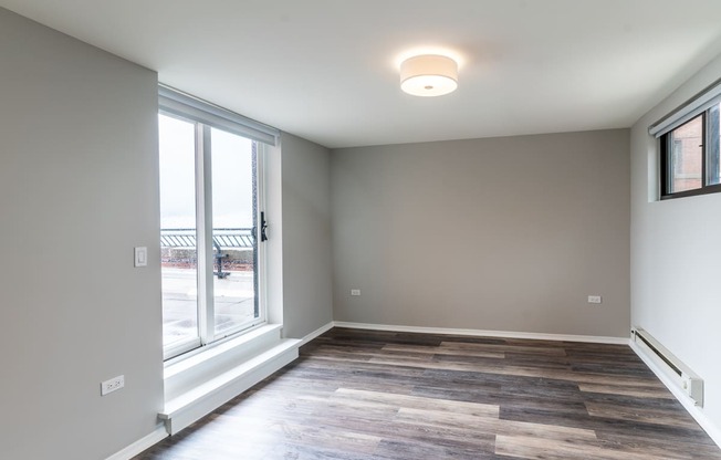 a living room with a large window and wood flooring