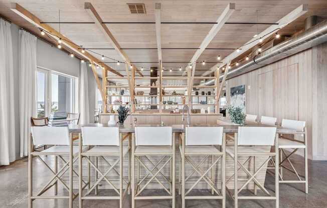 A long table with chairs is set up in a room with wooden beams on the ceiling.