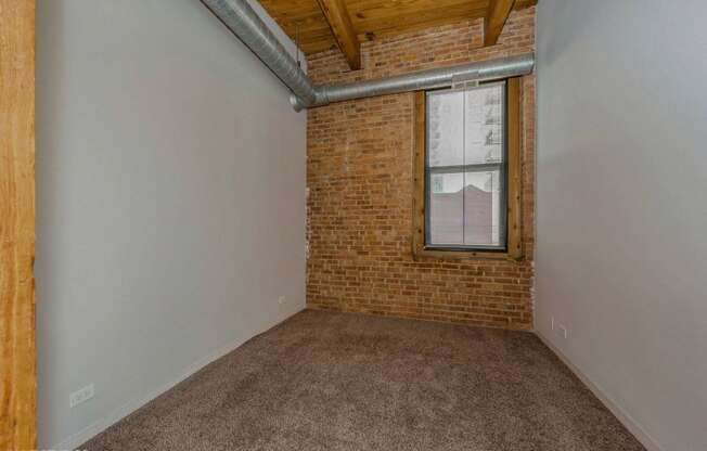 Bedroom with exposed brick wall at Carriage House Lofts, Chicago, IL, 60605