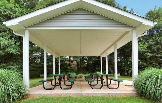 a pavilion with picnic tables in a park
