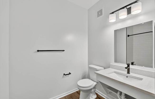 Renovated bathroom with toilet, sink and black fixtures