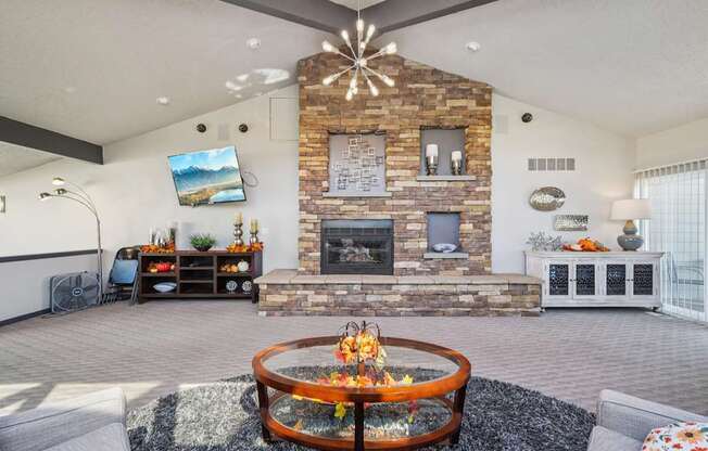 A modern living room with a stone fireplace and a television mounted on the wall.