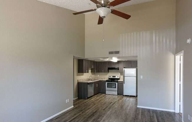 an empty kitchen with a ceiling fan