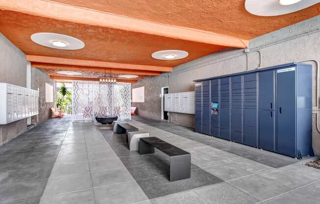 a long hallway with blue lockers and a row of benches